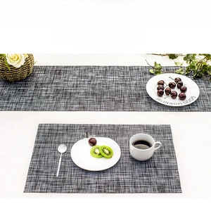 Close-up of woven PVC placemat set with linen texture and elegant table setting details