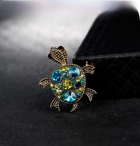 Detailed view of turtle brooch with vintage gold base and colorful rhinestones