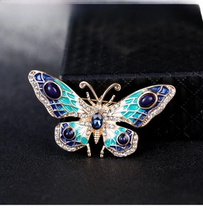 Macro shot of blue enamel butterfly brooch with crystal pavé and gold plating