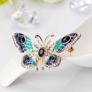 Exquisite gold butterfly brooch with blue enamel wings and sparkling white crystals