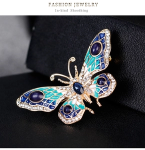 Detail of blue enamel butterfly brooch with crystals on premium black leather texture