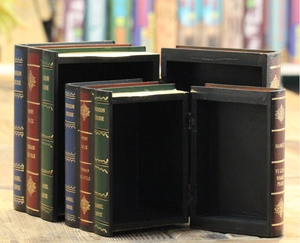 Detailed view of open antique book-shaped wooden storage boxes with gold-foil spine designs