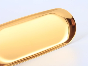Close-up of a polished gold oval stainless steel tray featuring smooth rounded edges