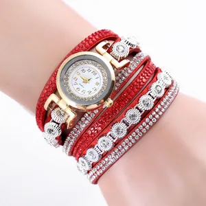 Close-up of red multi-layer rhinestone bracelet watch with a polished golden dial