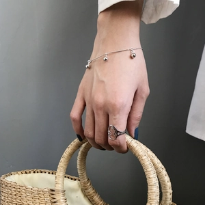 Detail of silver beaded snake chain bracelet and irregular open ring on model