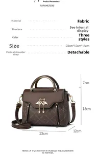 Detail showing brown fabric handbag dimensions 23x12x18cm with swan logo and charms