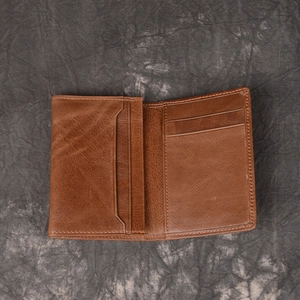 Interior view of brown genuine leather wallet showing symmetrical card slots and stitching