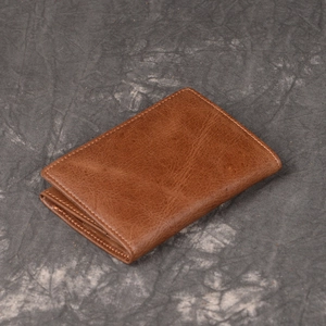 Close-up of vintage brown leather wallet texture and detailed stitching on folding card case