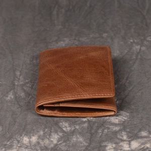 Detailed close-up of brown vintage leather wallet showing natural texture and stitching