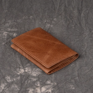 Detailed view of brown genuine leather texture and fine stitching on a vintage wallet