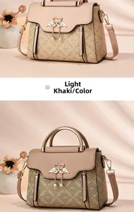 Detail of light khaki handbag featuring heart swan metal buckle and monogram print