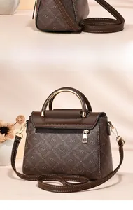 Detail of a brown monogram handbag with smooth metallic handle and rear zipper pocket