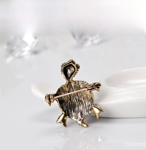 Detail view of the vintage turtle brooch with an antique bronze finish and safety pin back