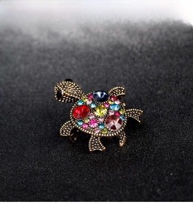 Macro shot of retro turtle brooch with colorful crystals on a bronze metal base