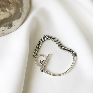 Detailed close-up of silver chain link bracelet with OT toggle clasp on fabric