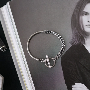 Detailed view of vintage silver chain bracelet with O-T buckle on fashion magazine page