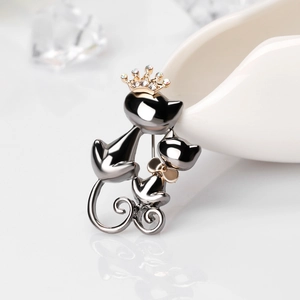 Broche chat double en métal avec couronne dorée et nœud sur céramique blanche