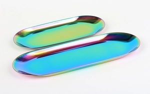 Pair of oval iridescent rainbow stainless steel trays in different sizes on white backdrop
