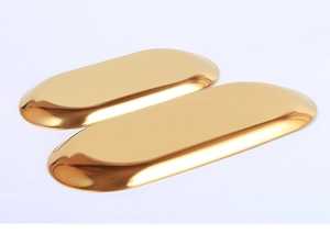 Detailed close-up of two polished gold oval stainless steel jewelry display trays