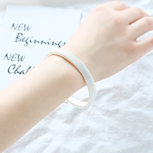 Detail of silver elastic spring armband sleeve holder on a minimalist white backdrop