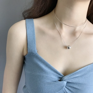 Detailed view of layered S925 sterling silver necklace with a 12mm ball pendant on a model