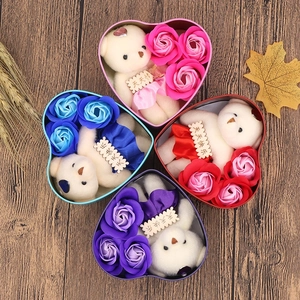 Macro detail of heart-shaped gift boxes with soap roses and small bears on wood