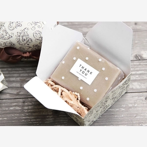 Detail view of vintage paisley gift box with beige pattern and shredded paper filling
