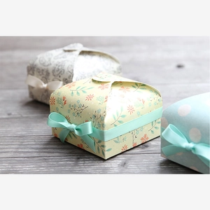 Detailed view of assorted vintage paper gift boxes with decorative ribbon bows on wood