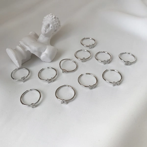 Artistic layout of 925 sterling silver letter rings on elegant white fabric background