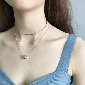 Close-up of a double-layer S925 silver necklace set featuring a minimalist ball pendant