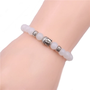 Detail of beaded bracelet with white translucent beads, alloy accents and Buddha charm