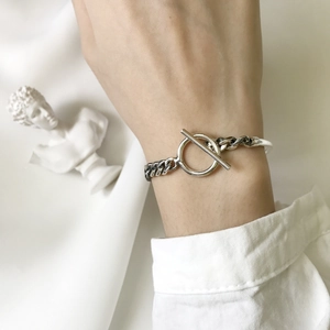 Detailed close-up of a sterling silver Cuban link bracelet with a stylish toggle clasp