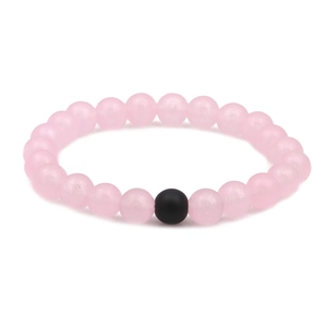 Detail showing smooth pink translucent beads and one matte black bead on the bracelet
