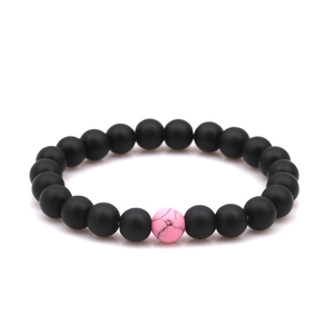 Detailed macro view of 8mm matte black beads and a pink marble pattern accent bead