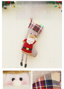 Detail of a large Santa-themed Christmas stocking with a 3D plush character on burlap fabric