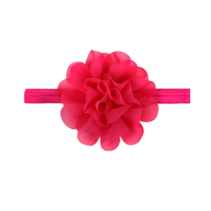 Detailed close-up of a pink handmade chiffon flower on a stretchable baby headband