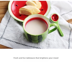 Detail of watermelon ceramic set showing mug and plate with vibrant fruit pattern