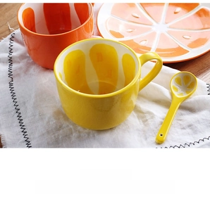 Detailed set of orange themed ceramic tableware with mug and plates on a wooden table