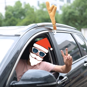 Plush brown reindeer antlers car decoration with festive ribbons on car window