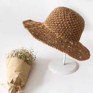 Handwoven coffee brown straw sun hat with wavy brim for beach and outdoor activities