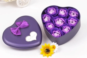 Macro view of purple heart-shaped gift box with soap roses and a large ribbon bow