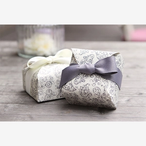 Close-up of vintage paisley pattern gift boxes with ribbons on a wooden table