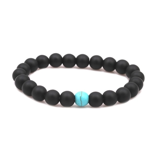Detail of 8mm matte black stone beaded bracelet with a blue natural turquoise accent bead