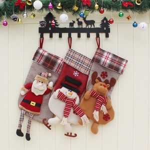 Three Christmas stockings with Santa, Snowman, and Reindeer on a metal deer wall rack
