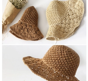 Close-up detail of hand-crocheted straw hats with hollow patterns in brown and beige colors