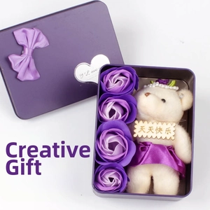 Detail of soap flower gift box with purple roses, plush bear, and a heart bow