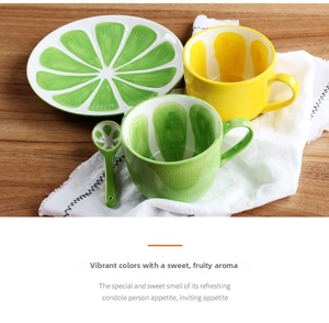 Detailed view of lime pattern ceramic plate and colorful fruit-themed mugs with matching spoon