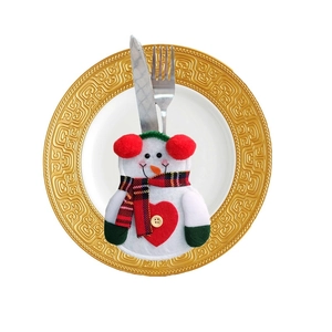 Detailed view of snowman cutlery holder with plaid scarf on plate for Christmas table
