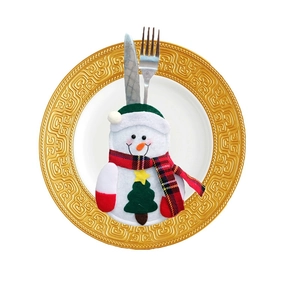 Christmas snowman cutlery holder on white ceramic plate with metal fork and knife inside