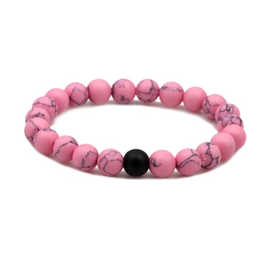Close-up of pink turquoise beads with black marble veins and a matte black bead on distance bracelet